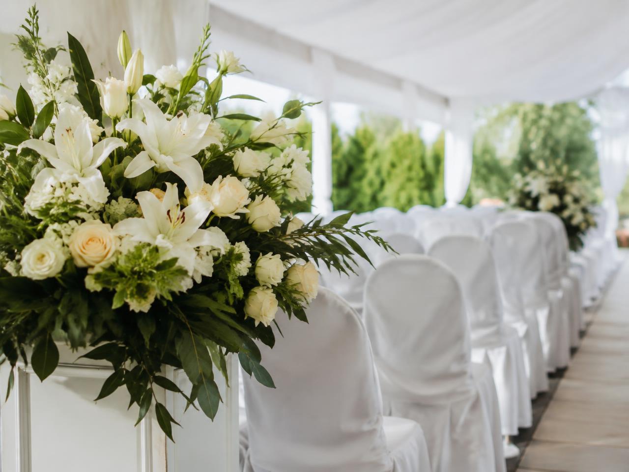 White lilies and draped chairs for a memorial service (illustrative image)
